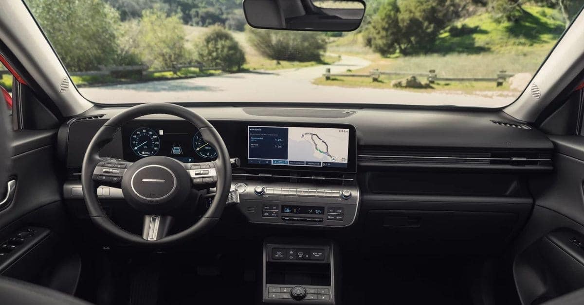 2026 Hyundai Kona interior showing dual digital screens, center console, climate control buttons, and front seats in a modern, minimalist layout.